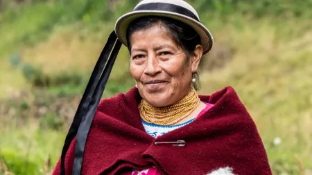 Woman wearing beige hat with burgundy poncho